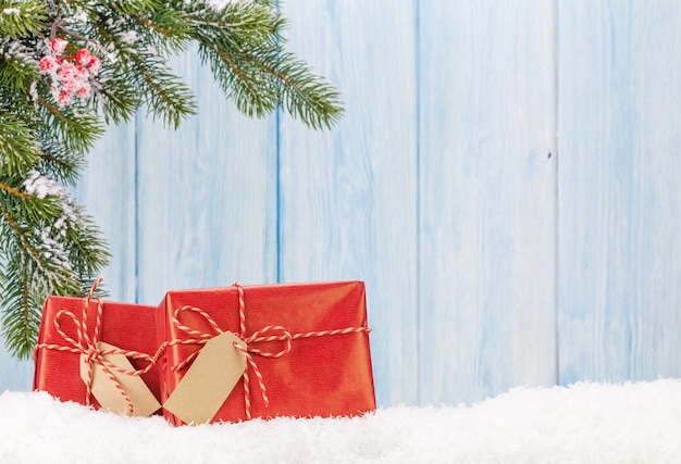 Coffrets cadeaux de Noël et branche de sapin dans la neige