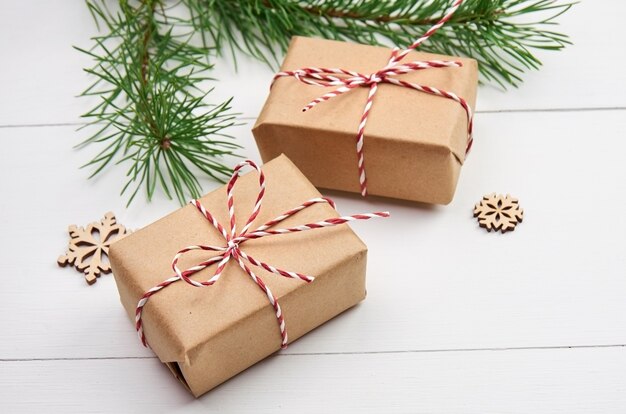 Coffrets cadeaux de Noël avec des branches de pin sur blanc