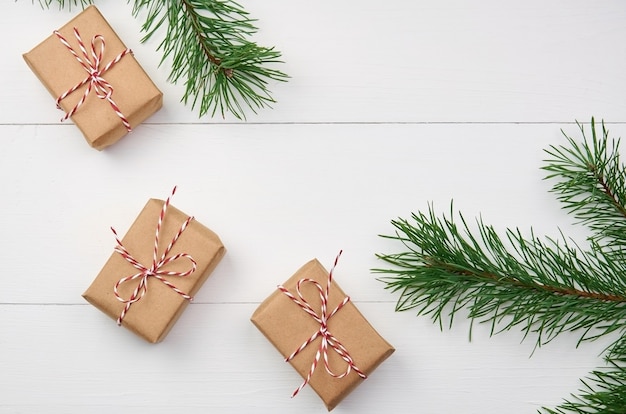 Coffrets cadeaux de Noël avec des branches de pin sur blanc