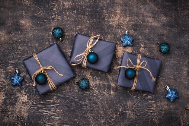 Coffrets cadeaux de Noël en papier bleu sur table en bois foncé