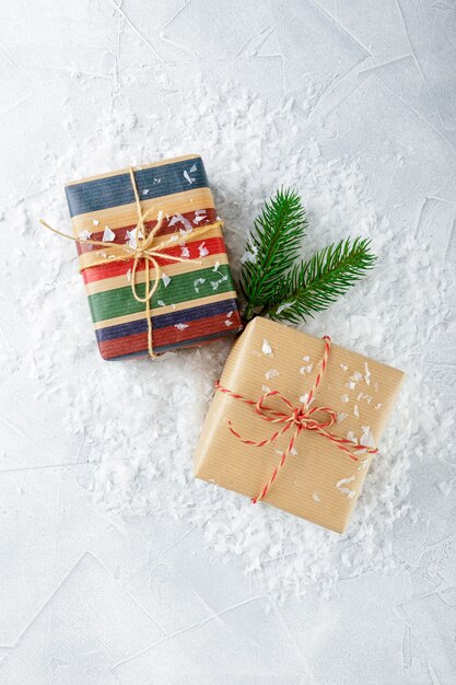 Coffrets cadeaux de Noël en papier kraft et branches d'épinette sur neige. Vue de dessus