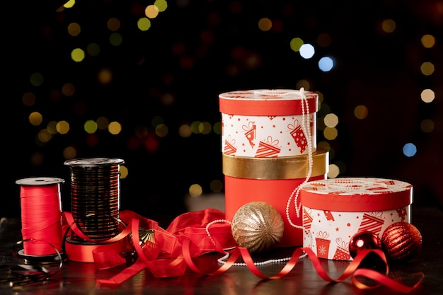 Coffrets cadeaux de Noël, ruban d'emballage et boules sur fond flou, attributs du nouvel an. photo de haute qualité