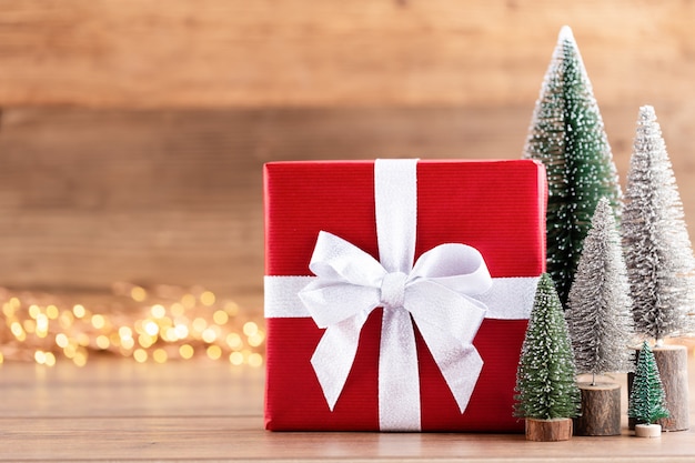 Coffrets cadeaux de Noël avec des rubans et des arbres sur fond de bokeh.