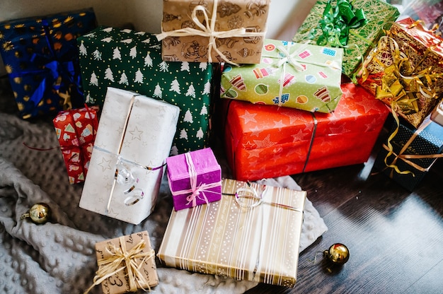 Coffrets cadeaux avec ornements sur bois marron, tricoté gris. espace pour le texte, la conception. Joyeuses fêtes. vue de dessus. cadeaux emballés élégants. joyeux noël, concept de nouvel an. anniversaire.