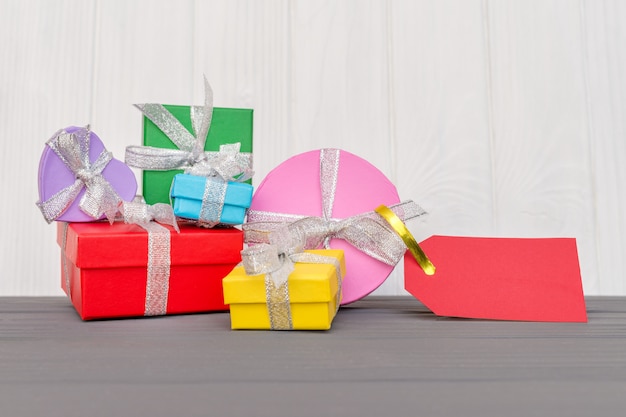 Photo les coffrets cadeaux sont attachés avec un ruban avec des mots boxing day et une étiquette rouge sur la surface en bois blanc