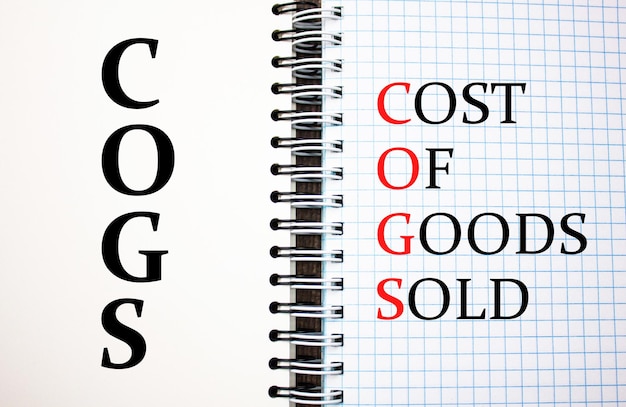 COGSCoût des marchandises vendues concept de texte sur le bloc-notes Abréviation COGS Business concept