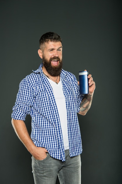 Coiffer et coiffer les cheveux de la bonne façon. Hipster avec barbe et moustache tenant un produit de soin des cheveux sur fond gris. Homme barbu appréciant le toilettage personnel. Soins et soins naturels pour hommes.