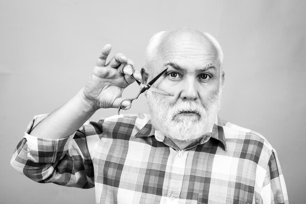 Coiffeur d'âge moyen homme avec des ciseaux de coiffeur homme traitement des cheveux