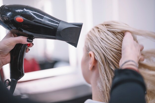 Photo coiffeur anonyme séchant les cheveux