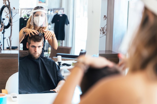 Coiffeur arrangeant les cheveux d'un client dans un salon