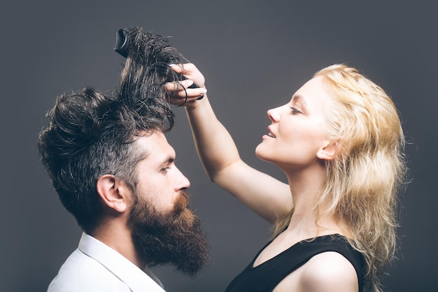 Coiffeur blond peignant l'homme barbu