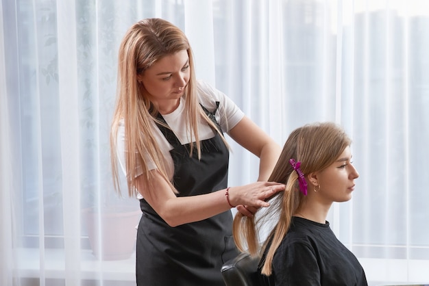 Coiffeur coiffage des cheveux d'un client dans un salon de beauté