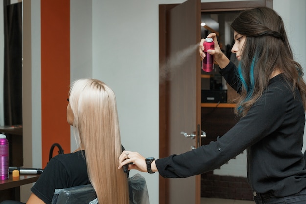 Le coiffeur coiffe les cheveux longs du client