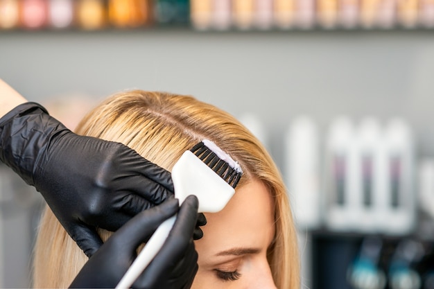 Photo le coiffeur colore les cheveux des clientes