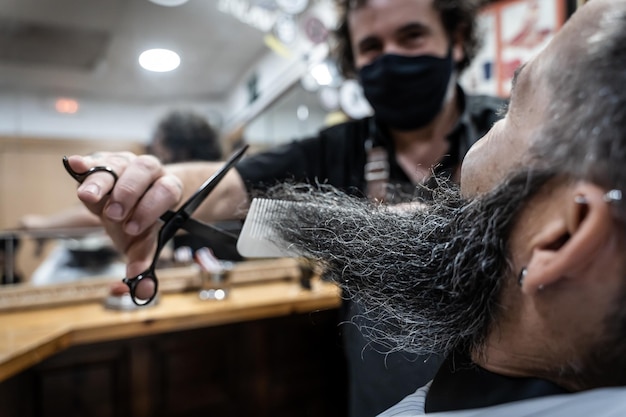 Coiffeur coupant la barbe d'un client dans un salon de coiffure