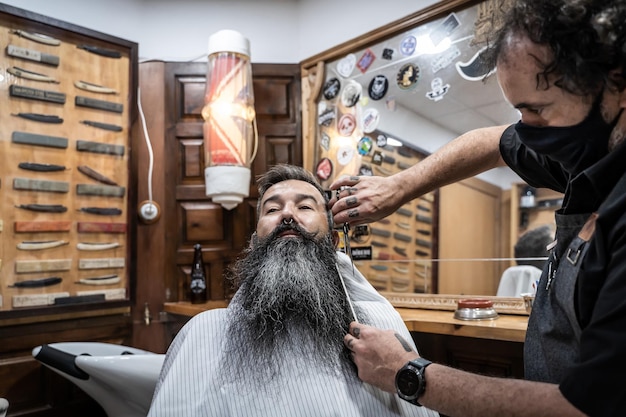 Coiffeur coupant la barbe d'un client