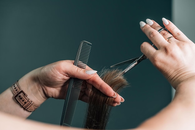 Coiffeur coupant les cheveux bruns ou blonds avec des ciseaux