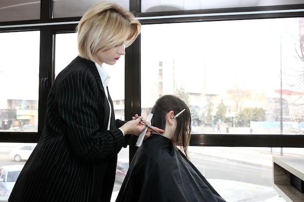 Coiffeur coupant les cheveux dans le salon agrandi