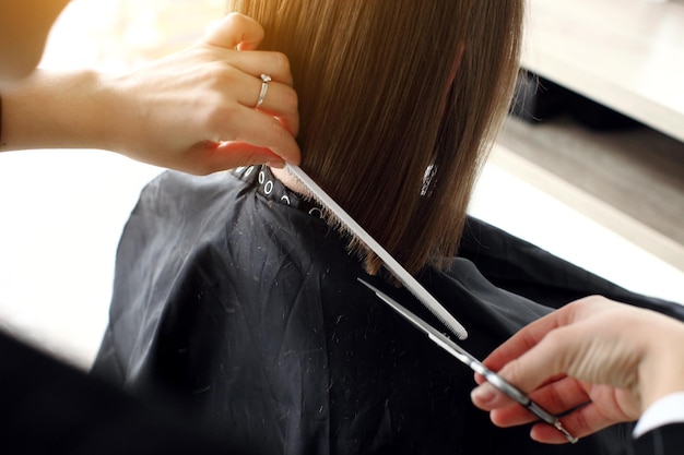 Coiffeur coupant les cheveux dans le salon agrandi