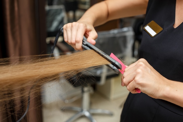 Le coiffeur coupe les cheveux du client.