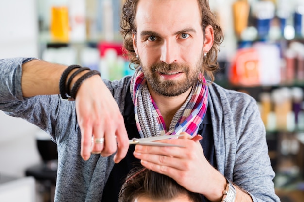 Coiffeur coupe les cheveux de l&#39;homme dans un magasin de cheveux