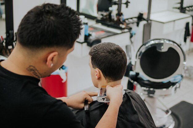 Photo le coiffeur coupe vos cheveux avec la tondeuse à cheveux