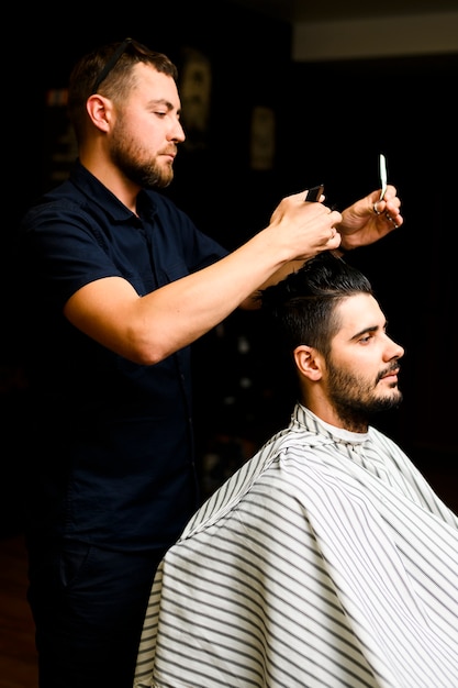 Photo coiffeur donnant à l'homme une nouvelle coiffure