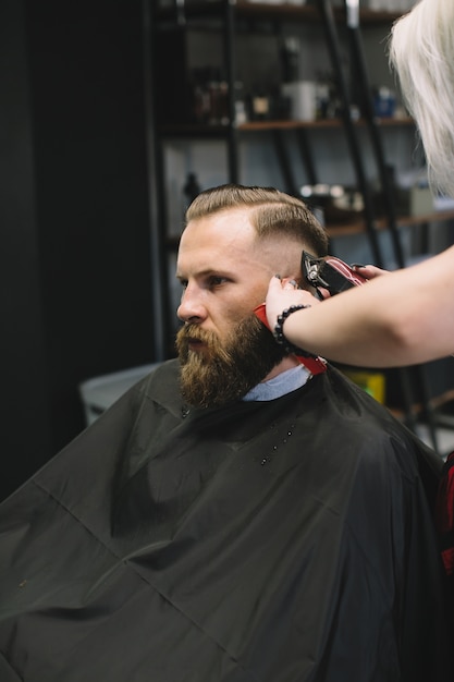 Coiffeur élégant Couper Les Cheveux Du Client Au Salon De Coiffure.