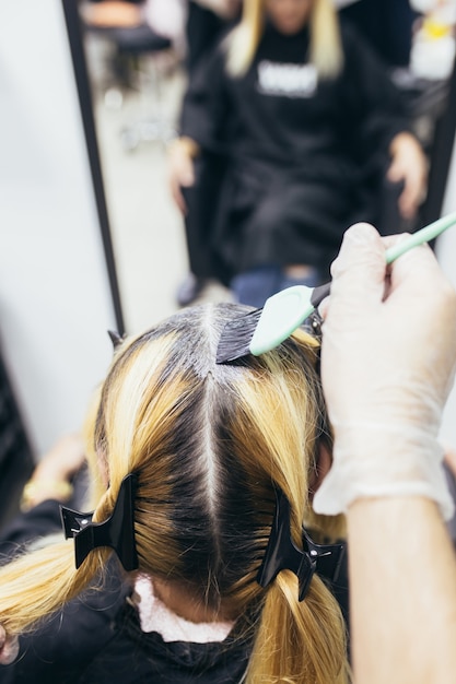 Le coiffeur est en train de mourir les cheveux des femmes