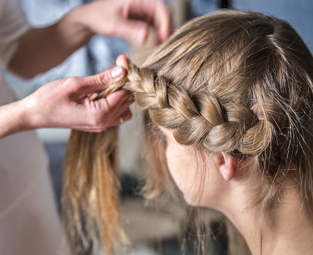 Coiffeur fait des tresses dans un salon de beauté