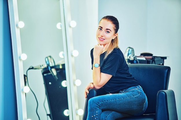 Coiffeur féminin au salon tenant un fer à lisser