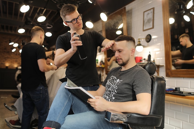 Coiffeur fixant la coupe de cheveux d'un homme