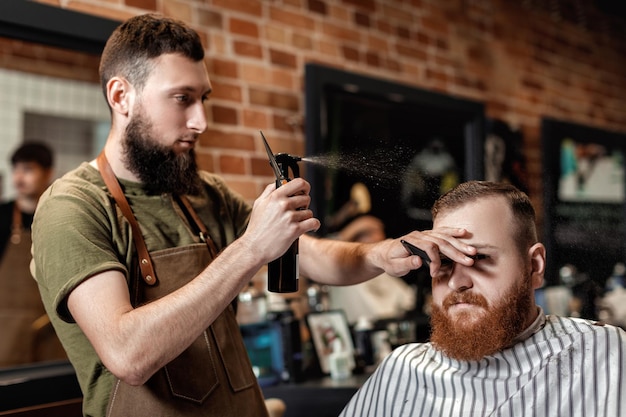 Coiffeur et homme barbu dans un salon de coiffure