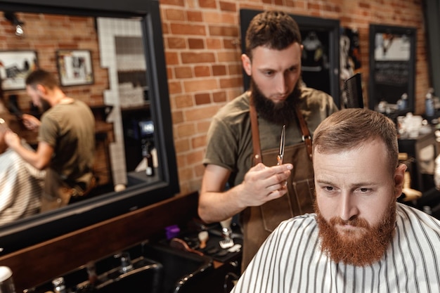 Coiffeur et homme barbu dans un salon de coiffure