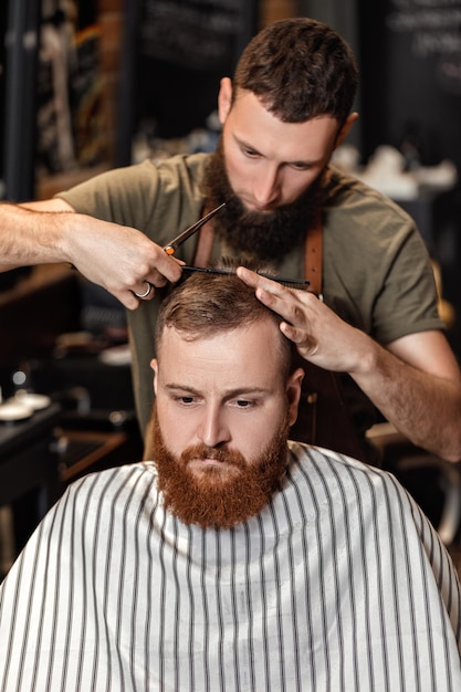 Coiffeur et homme barbu dans un salon de coiffure