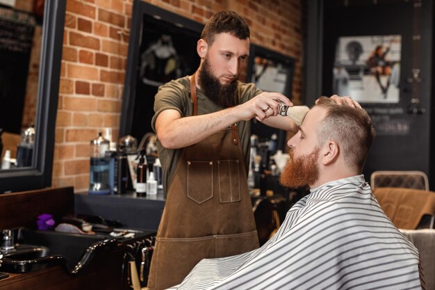 Coiffeur et homme barbu dans un salon de coiffure