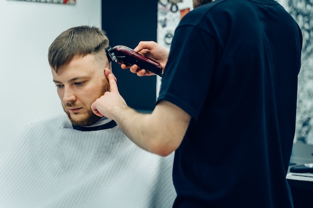 Coiffeur homme coupe les cheveux d'un client