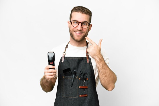 Coiffeur homme dans un tablier sur fond blanc isolé donnant un coup de pouce geste