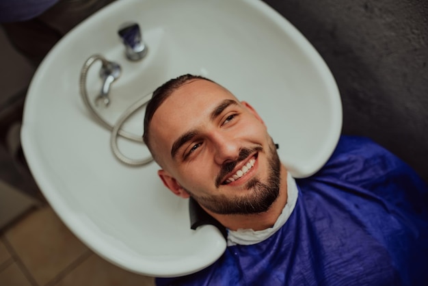 Coiffeur laver les cheveux du client dans un salon de coiffure Mise au point sélective Photo de haute qualité