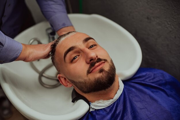 Coiffeur laver les cheveux du client dans un salon de coiffure. Mise au point sélective. Photo de haute qualité