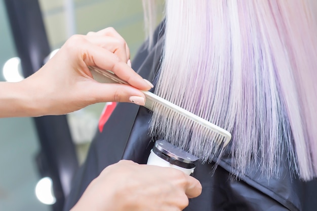 Coiffeur avec une machine à cheveux. couper les pointes fourchues des cheveux avec une tondeuse. fermer.