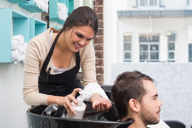 Coiffeur mettant conditionneur dans les cheveux de l&#39;homme