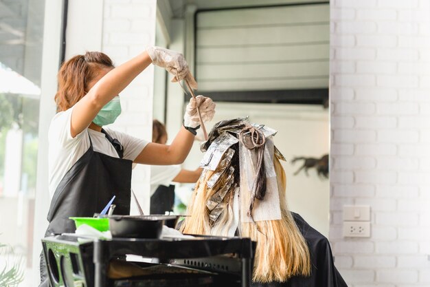 Un coiffeur meurt de cheveux féminins avec du papier d&#39;aluminium