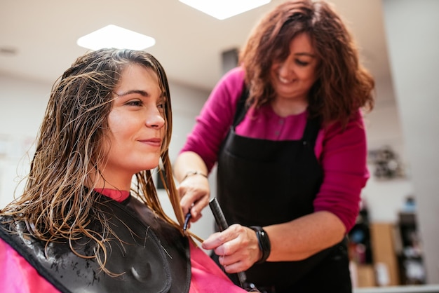 Coiffeur peignant les cheveux de la femme