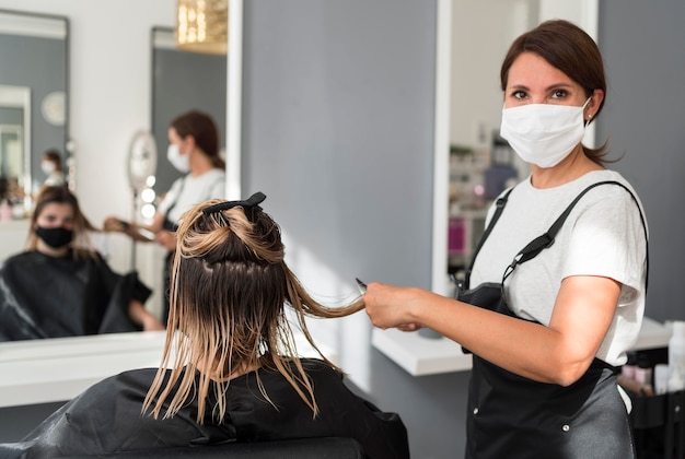 Photo coiffeur portant un masque en tissu et client