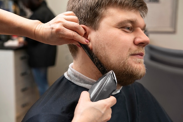 Photo coiffeur prenant soin de la barbe d'un client