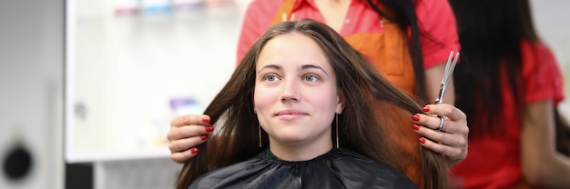 Le coiffeur principal tient les cheveux du client dans le salon de beauté