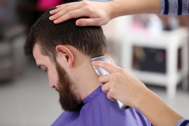 Coiffeur professionnel coupant les cheveux avec une tondeuse à cheveux