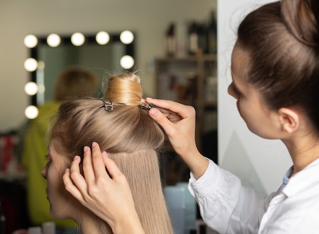 Coiffeur professionnel fixant et préparant les cheveux avant le coiffage