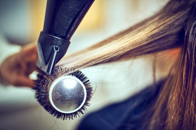 Coiffeur professionnel séchant les cheveux, en ctudio